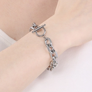 Close-up of silver stainless steel Cuban chain bracelet with OT clasp on wrist