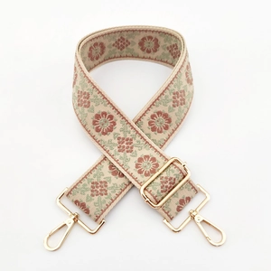 Close-up of ethnic floral embroidery on a wide beige replacement shoulder bag strap