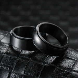 Two black spinner rings for meditation on leather base with premium matte finish