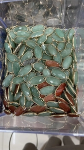 Macro shot of oval crystal connectors with gold plating and double loops for jewelry DIY