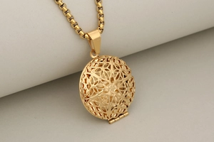 Detailed close-up of golden round hollow locket with intricate geometric patterns