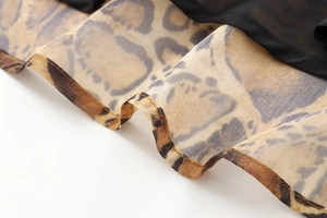 Detailed close-up of brown leopard print midi dress fabric and high-quality hem stitching
