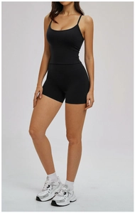 Detail of 2-piece black women's yoga set showing elastic high-waist shorts and U-neck tank top