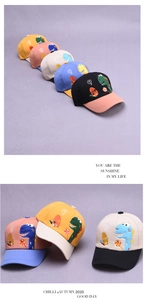 Detail showing cartoon dinosaur embroidery and color-blocked designs on kids' baseball caps