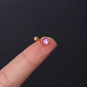 Macro shot of 20G stainless steel piercing stud with pink moonstone on a fingertip