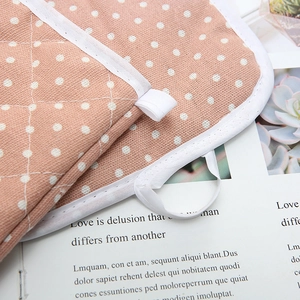 Detailed view of pink polka dot oven mitt material with diamond quilting and hanging loop