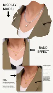 Detail of layered stainless steel snake chain necklace with teardrop pendant in gold and silver