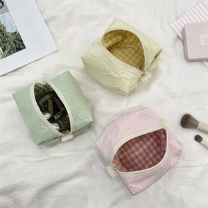Détails de trousses de maquillage gaufrées de cœurs avec doublure à carreaux chic