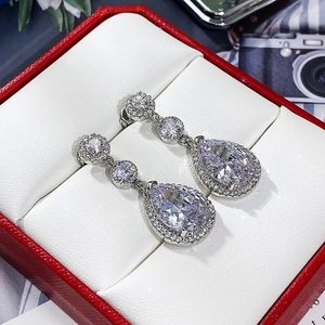Macro shot of silver teardrop earrings with AAA cubic zirconia in a red gift box