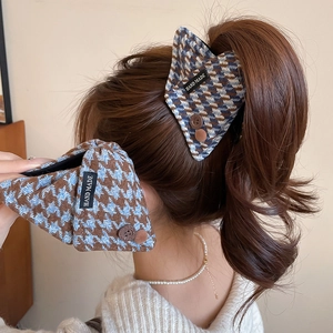Detail of plaid houndstooth hair claw clips with buttons and handmade labels on hair
