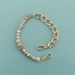 Detail of bohemian acrylic chain with gold metal links and natural stone beads