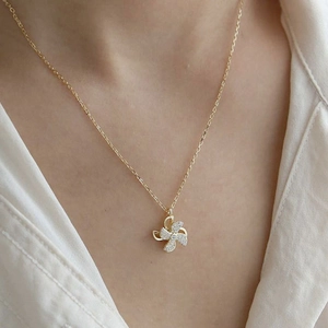 Detailed view of rotating windmill necklace with sparkling crystals on golden chain