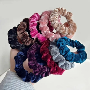 Close-up of velvet scrunchies in multiple colors showing soft pleated texture