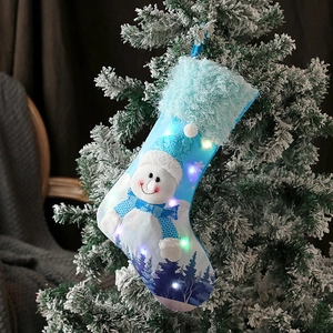 Blue LED Christmas stocking with snowman pattern hanging on a festive snowy Christmas tree