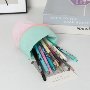 Detailed view of pink plaid pencil bag with mint green canvas and orange zipper