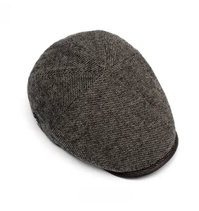 Top view of retro British flat cap showing brown textured tweed fabric and brim detail