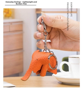 Detail of orange genuine leather elephant keychain with lychee texture held in hand