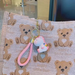 Cute unicorn keychain with pink braided strap on canvas bag, perfect for backpack charm
