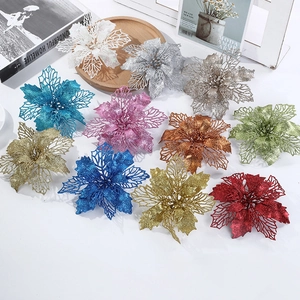 Flat lay of colorful hollow glitter poinsettia flowers on a wooden tray for Christmas decor