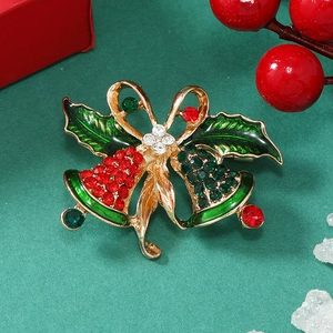 Detailed close-up of a Christmas bell brooch with red enamel and sparkling rhinestones