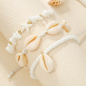 Close-up of bohemian starfish charms and natural cowrie shell beads on beach jewelry