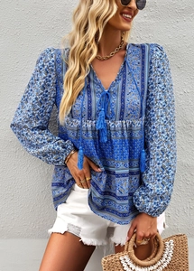 Detail of bohemian blue printed blouse featuring decorative neckline tassels and long sleeves