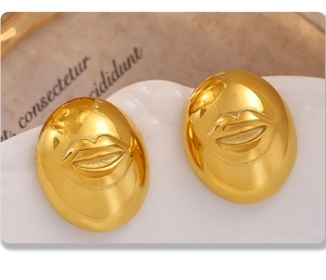 Gedetailleerde close-up van gouden ovale oorknopjes met een reliëf lippatroon in retrostijl