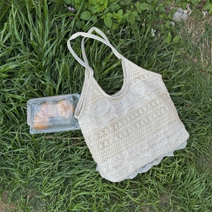 Gros plan détaillé du sac cabas en dentelle crème sur l'herbe pour un style pique-nique