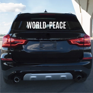 Close-up of World Peace white vinyl sticker applied on a black car rear window glass