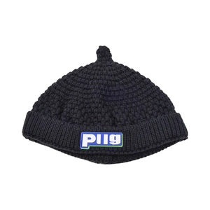 Detail of black knit baby beanie with textured weave and blue Plig rubber logo label