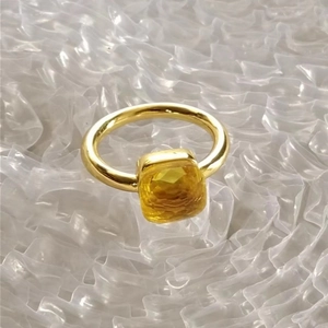 Detail of gold stainless steel ring featuring a square yellow zircon stone inlay