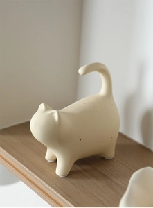 Detail view of cream ceramic cat statue with black spots and anti-slip bottom pads