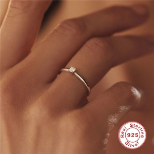 Close-up of minimalist 925 sterling silver solitaire ring worn on a woman's finger