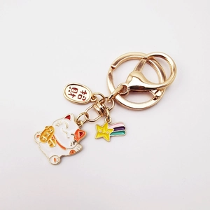 Golden Japanese lucky cat keychain with rainbow star and Fortune charm on white background