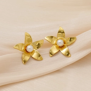 Golden titanium steel flower earrings with pearls on pink silk background