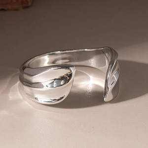 Macro shot of silver irregular wave textured acrylic bangle with high-gloss mirror finish