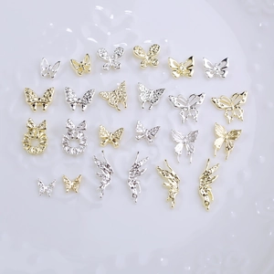 Detailed view of assorted gold and silver butterfly metal charms for nail art design