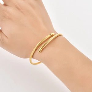 Classic gold stainless steel cable twisted wire open cuff bracelet on female wrist