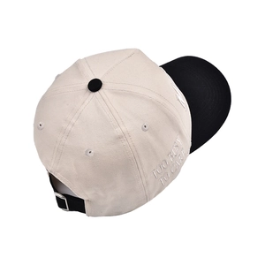 Detail of MOMMIN baseball cap featuring side embroidery and contrast brim texture