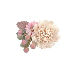 Detail of floral hair clip featuring fabric petals, resin berries and rhinestone center