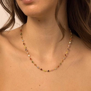 Close-up of 18K gold plated necklace with colorful round gemstones on female model