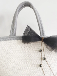 Handwoven cotton rope tote bag with mesh bow and polka dot bead pendant detail