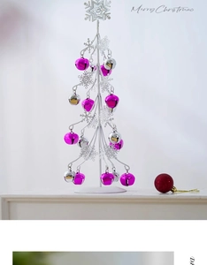 Detail eines weißen Metall-Weihnachtsbaums mit lila Glocken und Schneeflocken-Spitze