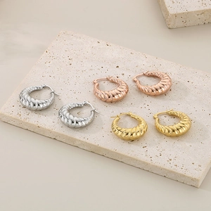 Detailed view of twisted croissant hoop earrings in silver, rose gold, and gold finishes