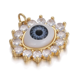 Detailed view of a gold evil eye pendant with white zircon stones and resin center