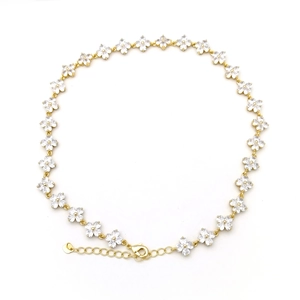 Detailed macro view of gold-plated flower link necklace with sparkling zircon accents