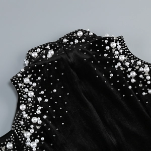Detail of high neck black velvet dress with elegant faux pearls and sparkling rhinestones