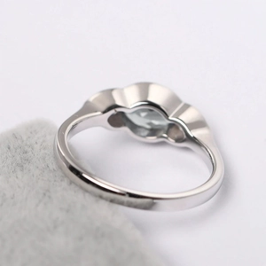 Macro shot of silver ring featuring a polished geometric setting with a clear gemstone