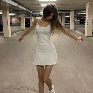 Close-up of white ribbed bodycon mini dress showing the slim fit textured fabric