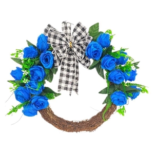 Blue rose Christmas wreath with green leaves and a black and white checkered bow on rattan